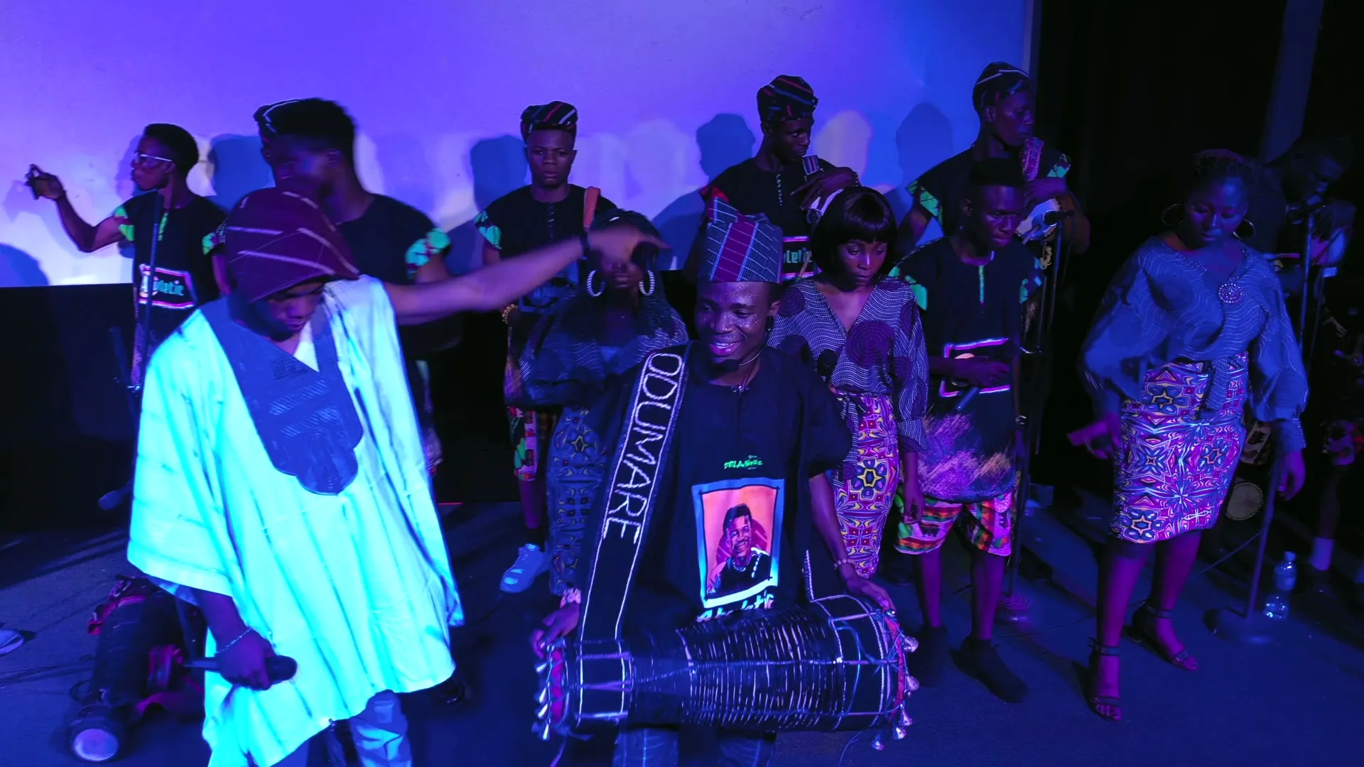 A performer in agbada and a drummer, from above