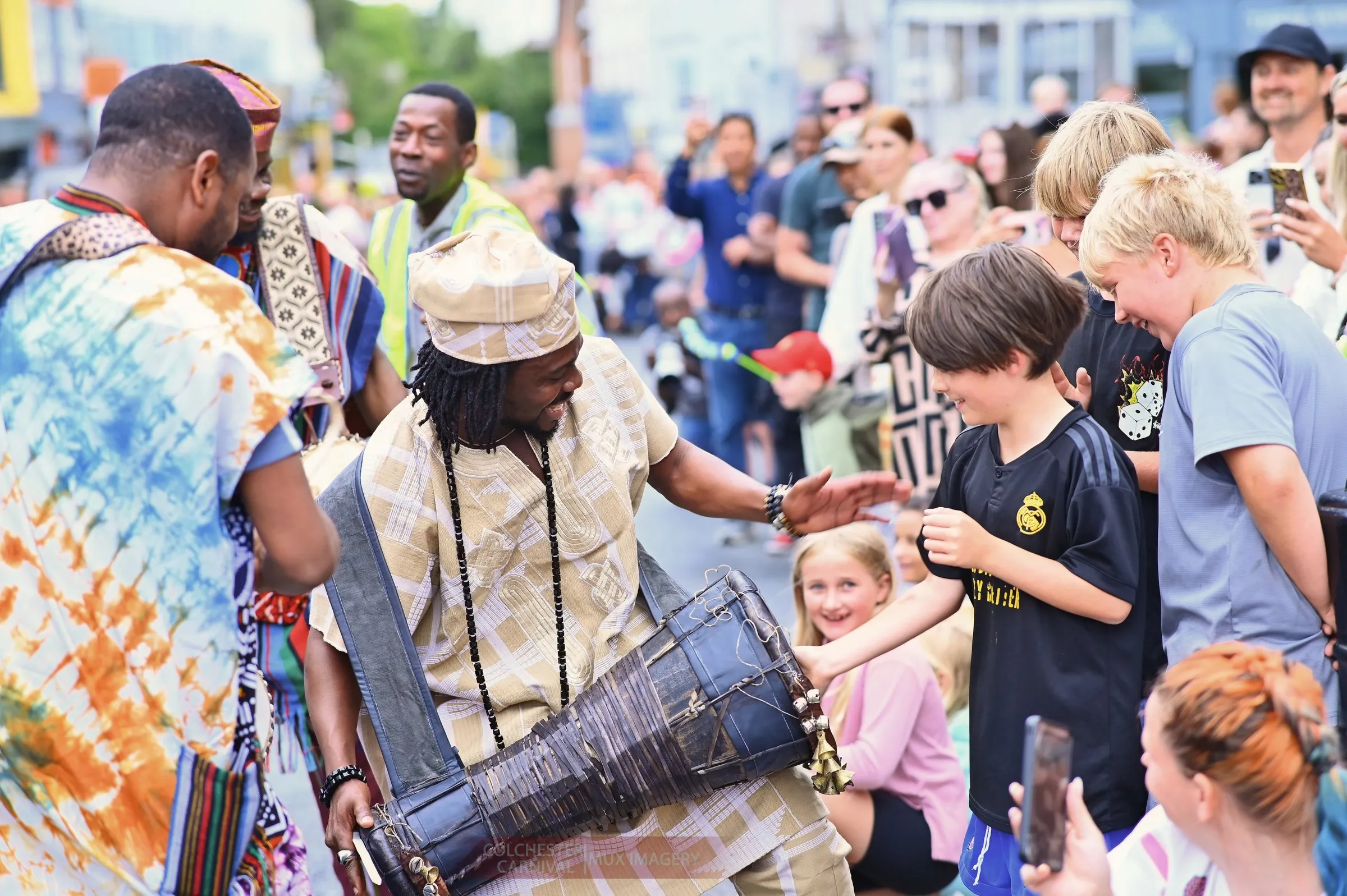 A young spectator plays the drum